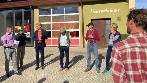 Mehrere Personen stehen vor dem Feuerwehrhaus.