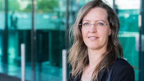 Porträtaufnahme einer Frau mit langen Haaren und Brille