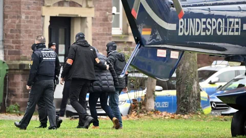 Polizisten mit einer verhafteten Person, Polizeihelikopter.