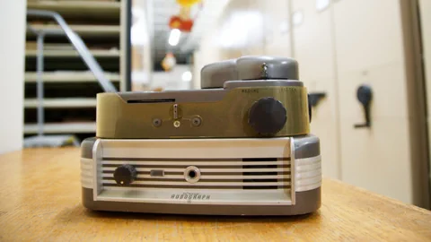 Altes Audiogerät auf Holztisch in Lagerraum.