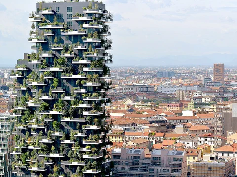 Hochhaus mit bepflanzten Balkonen in städtischer Umgebung.