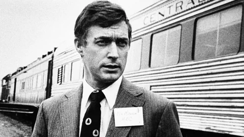 Mann im Anzug vor einem Zug.