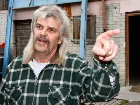 Person mit langem Haar und Plaid-Hemd zeigt auf etwas.