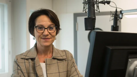 Eine Frau mit Brille am Mikrofon.