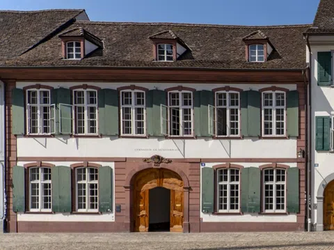 Historisches Gebäude mit grünen Fensterläden und offenem Tor.