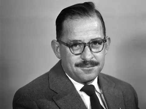 Ein Mann mit Brille und Schnauz