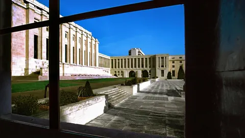 Blick aus dem Fenster auf Gebäude mit Säulen und blauen Himmel.