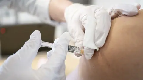 Impfung mit Spritze in den Arm, Nahaufnahme.