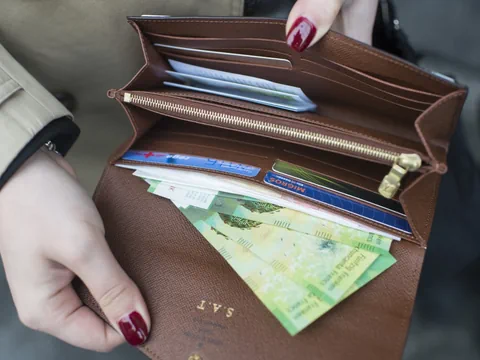 Offene Geldbörse mit Geldscheinen und Karten.