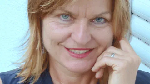 Eine blonde Frau mit blauen Augen.