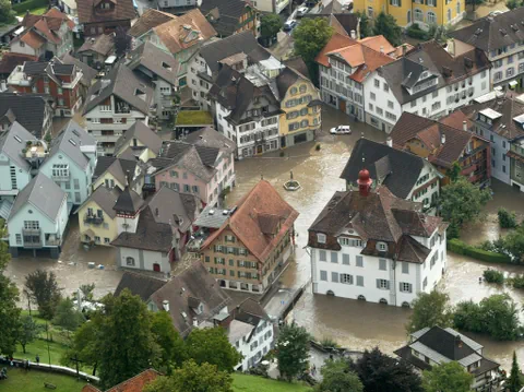 Luftaufnahme von überfluteter Stadt mit eng stehenden Häusern.