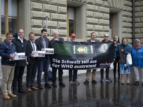 Eine Gruppe Menschen mit einem Plakat, auf dem steht: «Die Schweiz soll aus der WHO austreten»