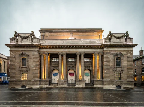 Historisches Gebäude mit Säulen und Beleuchtung.