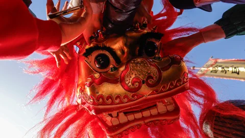 Nahaufnahme eines roten Drachentanzkostüms mit Händen.