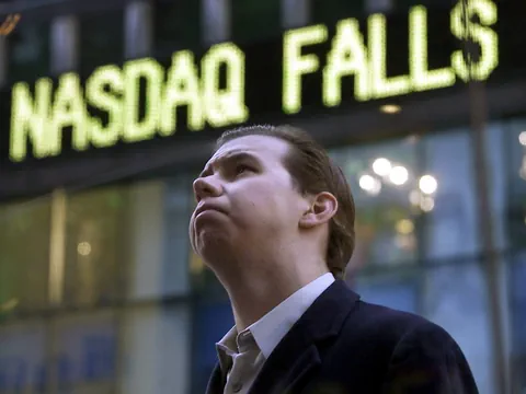 Mann vor NASDAQ-Bildschirm mit fallenden Kursen.