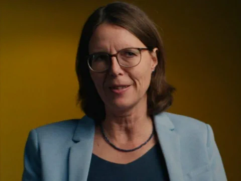 Marianne Meier vor einem gelbem Hintergrund.
