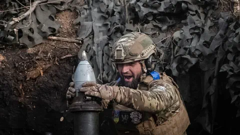 Ukrainischer Soldat feuert eine Artillerie-Granate ab