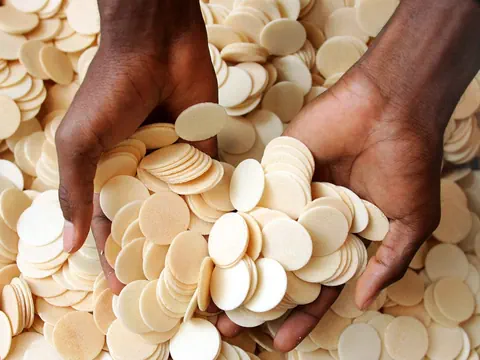 Hände halten viele runde Oblaten.