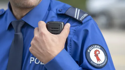 Polizeibeamter in blauer Uniform mit Funkgerät.