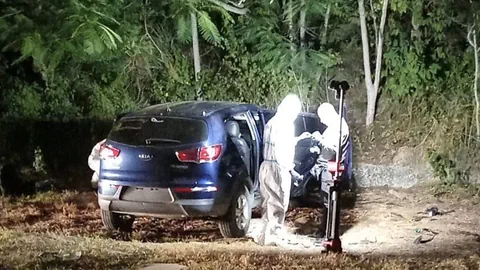 Mordschauplatz: Kriminaltechniker untersuchen das Auto am Strand.