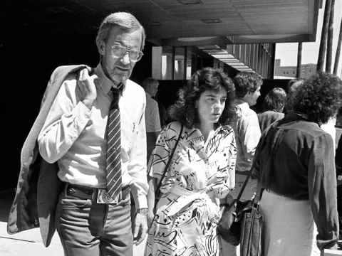 Mann und Frau in Geschäftskleidung gehen zusammen.