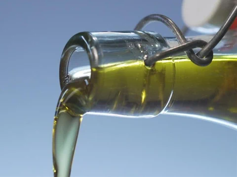 Olivenöl wird aus Flasche gegossen