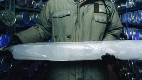 Ein Mann hält einen Eisbohrkern.