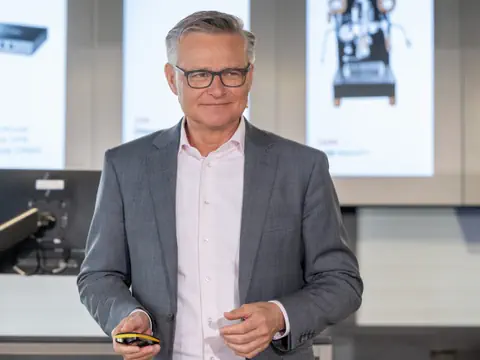 Mann in Anzug hält Präsentation.