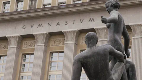 Haupteingang am Gymnasium Krichenfeld mit einer Statue im Vordergrund
