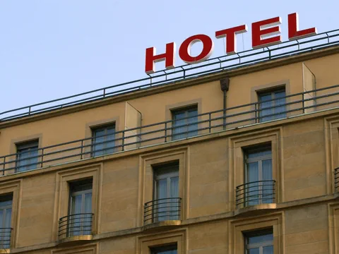 Hotelgebäude mit grossem roten Hotelschriftzug.