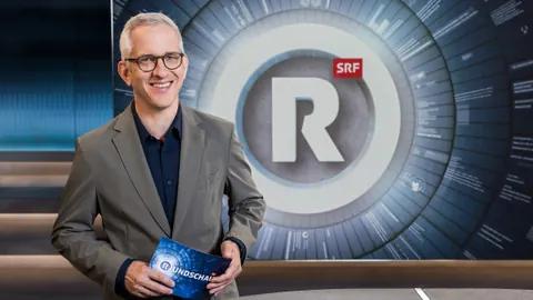 Moderator Gion-Duri Vincenz vor dem Rundschau-Logo im Studio