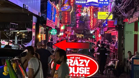 Belebte Strasse in Bangkok mit leuchtenden Neonschildern