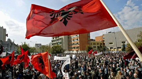 Menschenmenge bei Protest mit albanischen Flaggen.
