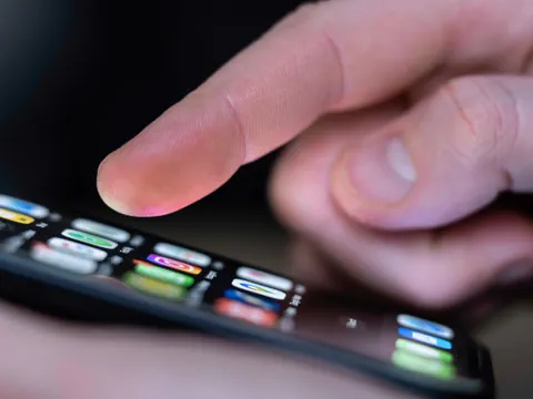 Nahaufnahme eines Fingers, der ein Smartphone berührt.