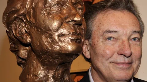 Karel Gott neben einer Büste von ihm.