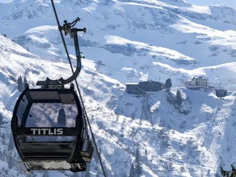 Titlis-Seilbahn vor schneebedecktem Bergpanorama.