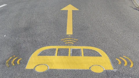 Gelbes Bus-Symbol mit Richtungspfeil auf Strasse.