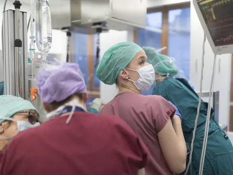 Ärzte und Krankenschwestern im Operationssaal mit Überwachungsmonitor.