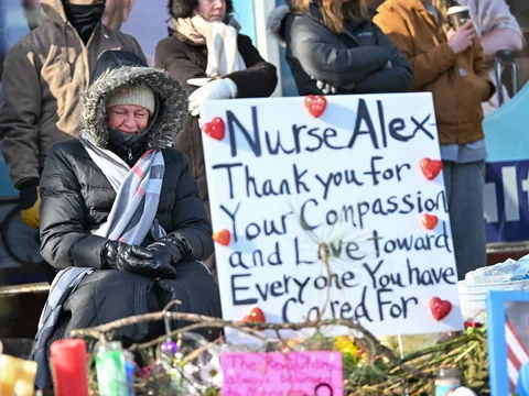 Frau weint neben Plakat mit der Aufschrift «Nurse Alex Thank you for your compassion ...»  