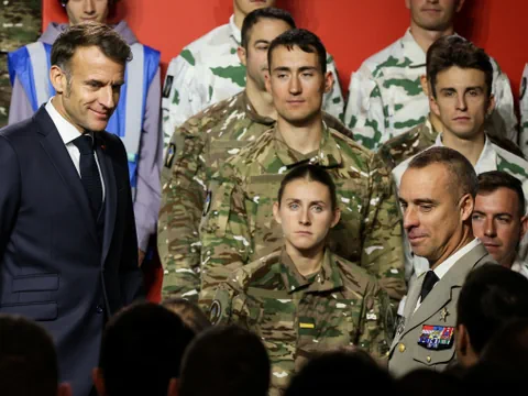 Gruppe von Militärangehörigen mit zwei Männern in Uniformen im Vordergrund.
