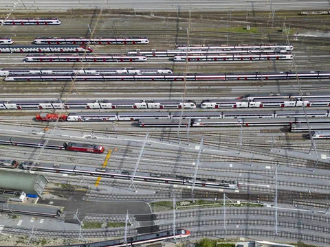 Luftaufnahme eines Bahnhofs mit mehreren Zuggleisen und Züge.