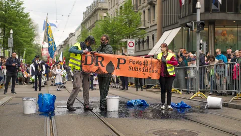 Klimaaktivisten mit einem Transparent am Sechseläuten-Umzug.