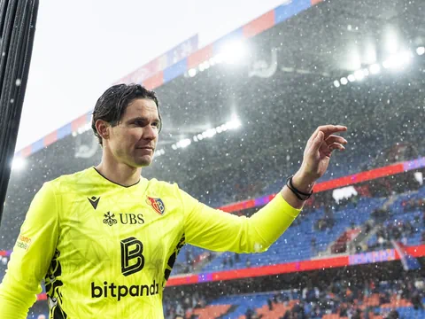 Fussballspieler in gelbem Trikot unter Regen.