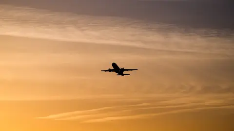 Flugzeug am Himmel während Sonnenuntergang.