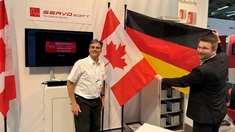 Zwei Männer an der Messe mit kanadischer und deutscher Landesflagge.