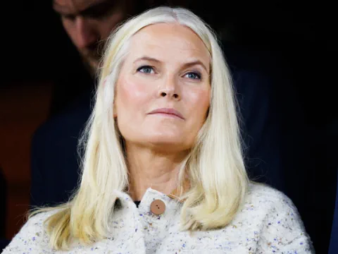 Frau mit langen blonden Haaren blickt nachdenklich.