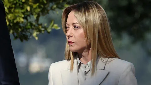 Frau im weissen Mantel im Freien.