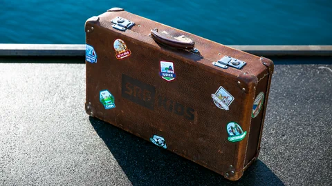 Der SRF Kids Koffer mit Aufklebern am Wasser.