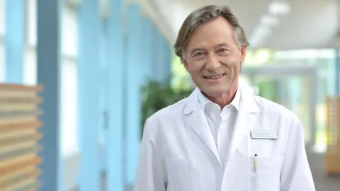 Thierry Ettlin in weissem Artztkittel
