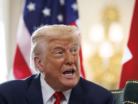 Person spricht vor amerikanischer Flagge.